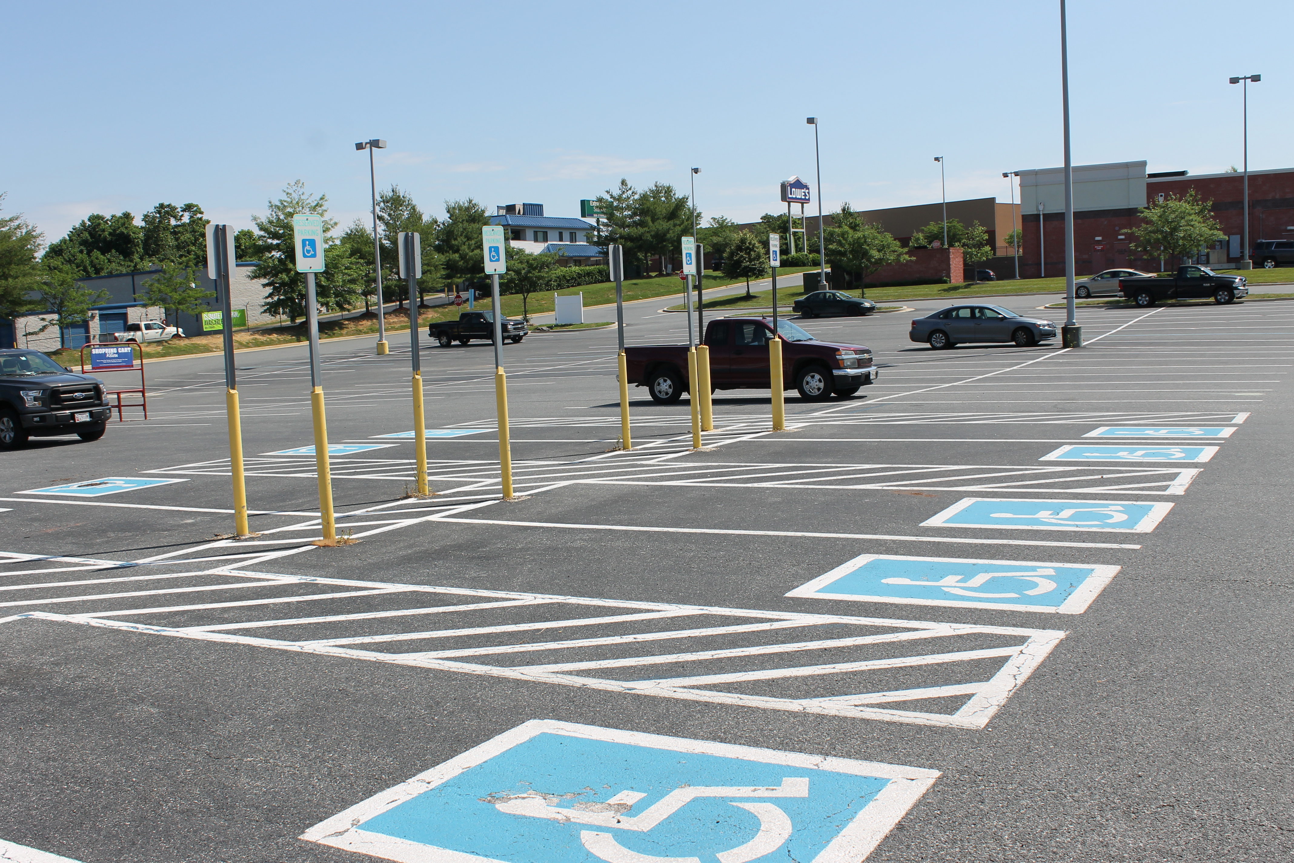Photo shows a row of accessible parking spaces.
